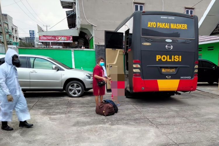 Seorang pasien isoman saat dijemput dan dipindahkan ke tempat isolasi pemerintah oleh pihak kepolisian.