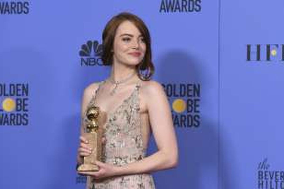 Aktris Emma Stone berpose bersama trofi aktris terbaik untuk film musikal/komedi pada ajang Golden Globe Awards 2017 yang digelar di Beverly Hills, California, Minggu (8/1/2017).