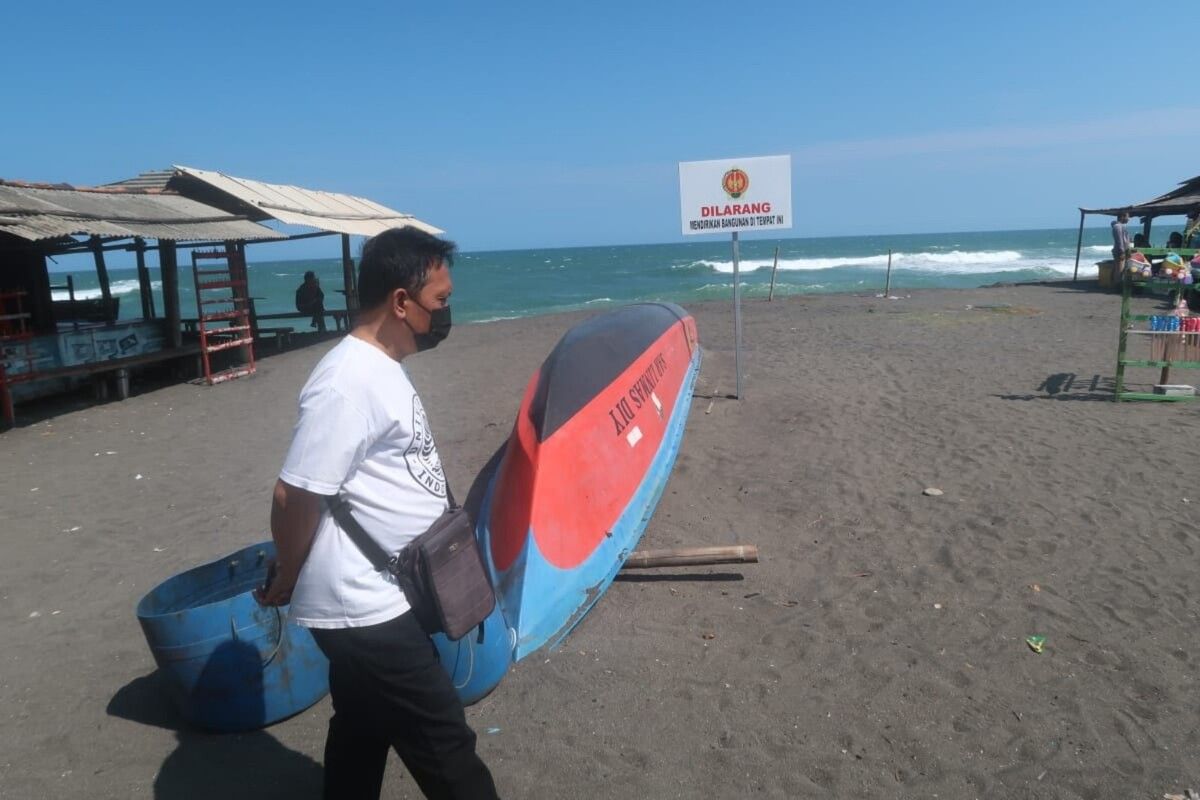 Warga melintas di sekitar Pelang Larangan Mendirikan bangunan di Pantai Depok, Bantul Selasa (19/7/2022).