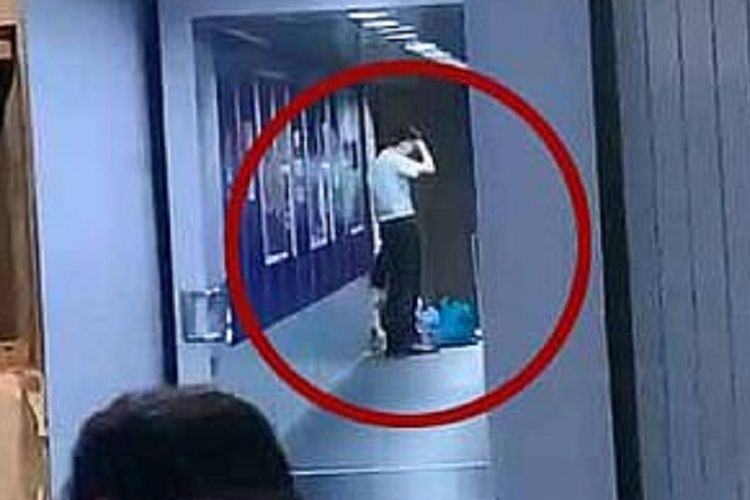 Gambar dengan lingkaran merah menunjukkan seorang petugas maskapai Spring Airlines berusaha berbicara dengan ibu yang berbaring di garbarata. Ibu itu berbaring demi mencegah pesawat menutup pintu setelah anaknya belum selesai belanja.