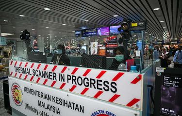 Petugas kesehatan Malaysia melakukan pemindaian suhu tubuh penumpang yang baru tiba dengan menggunakan thermal scanner, di Bandara Internasional Kuala Lumpur di Sepang, Selasa (21/1/2020 ). Hingga saat ini, sudah 12 negara di berbagai belahan Bumi yang positif mengumumkan terdampak virus corona yang dilaporkan sudah menjangkiti 1.300 orang dan membunuh 41 orang di China.