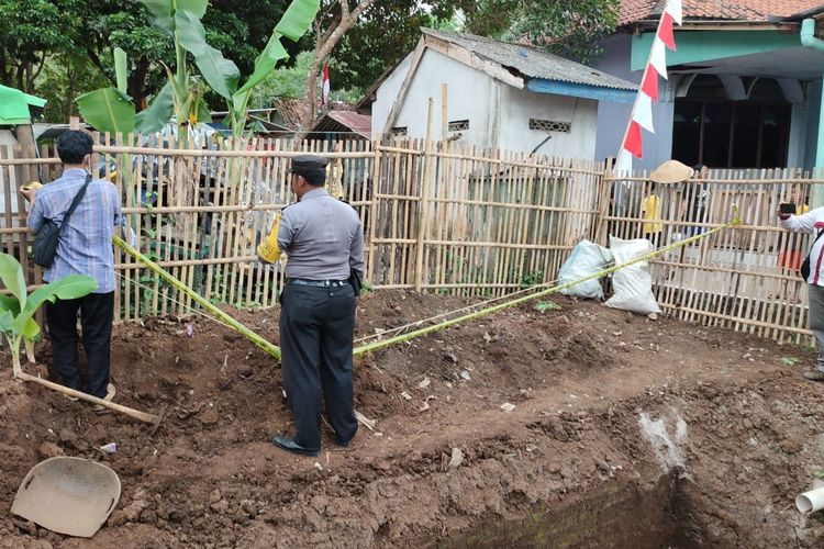 Polisi memasang police line agara warga tidak mendekati mortir yang ditemukan di kebun milik warga. 