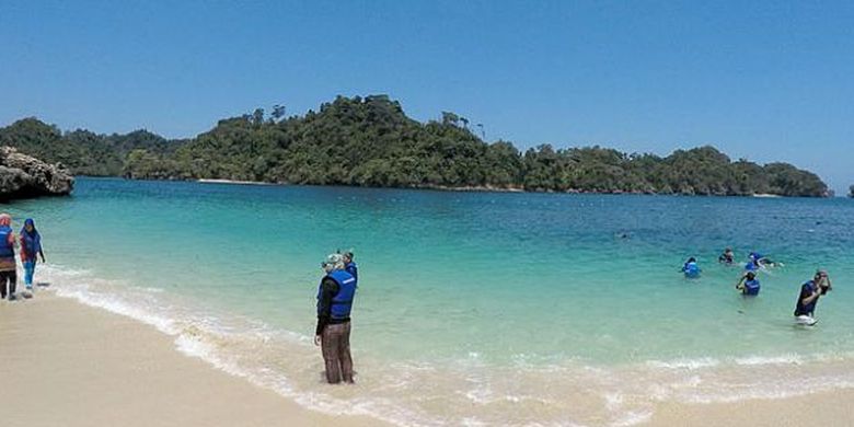 Pengunjung menikmati keelokan Pantai Tiga Warna di Desa Sendang Biru, Kecamatan Sumbermanjing Wetan, Kabupaten Malang, Jawa Timur, September lalu. Pantai Tiga Warna menyuguhkan keelokan alam, berpadu dengan nuansa konservasi mangrove dan wisata petualangan.