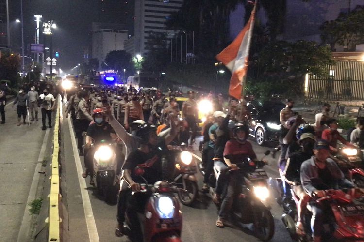 Personel Brimob Polri bersenjata lengkap dikerahkan untuk membubarkan massa pendukung klub sepak bola Persija Jakarta di kawasan Bundaran HI, Jakarta Pusat, Senin (26/4/2021) dini hari.