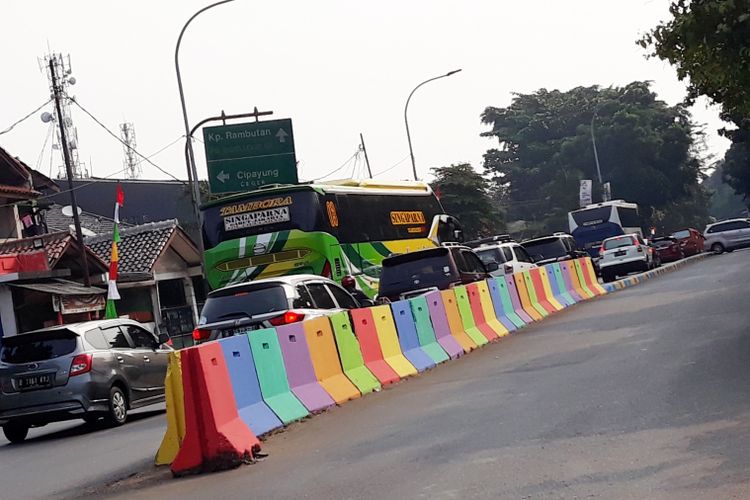 Separator jalan dihiasi warna-warni di kawasan TMII, Jakarta Timur, Minggu (29/7/2018)