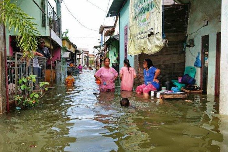 Warga Tambak Mulyo, Kota Semarang, Jawa Tengah, berakktivitas di tengah banjir rob yang melanda daerahnya, Senin (23/5/2022).