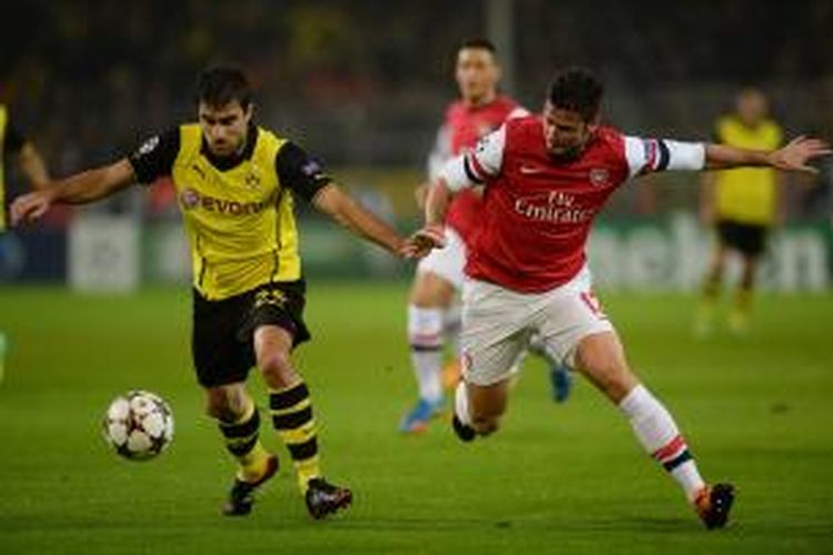 Penyerang Arsenal Olivier Giroud (kanan) berebut bola dengan bek Borussia Dortmund Sokratis Papastathopoulos, pada matchday keempat Grup F Liga Champions, di Signal Iduna Park, Rabu (6/11/2013).