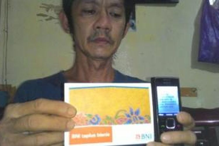 Suparman menunjukkan rekening tabungan BNI miliknya serta SMS Banking yang menyatakan uang Rp 5,1 miliar masuk ke rekeningnya, Senin (9/11/2015). Uang nyasar tersebut masuk rekening Suparman pada 2 Februari 2015 lalu. 