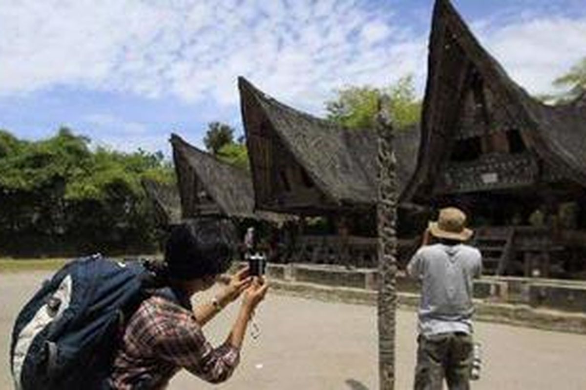 Anggota tim Ekspedisi Cincin Api Kompas mendokumentasikan kawasan rumah adat Batak di di Huta Bolon, Kecamatan Simanindo, Kabupaten Samosir, Sumatera Utara, Sabtu (23/7/2011).