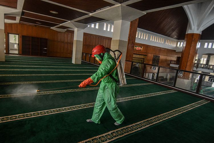 Tim Crisis Center Covid-19 Kota Tasikmalaya menggunakan Alat Pelindung Diri (APD) dari jas hujan plastik menyemprotkan cairan disinfektan di Masjid Agung Kota Tasikmalaya, Jawa Barat, Rabu (18/3/2020). Pemda setempat mengerahkan Tim Crisis Center Covid-19 menyemprotkan cairan disinfektan di berbagai tempat seperti Mesjid Agung, Bandara Wiriadinata, Pul Bus Budiman dan Primajasa untuk mencegah penyebaran virus Corona yang telah ditetapkan sebagai pandemik oleh World Health Organization (WHO).