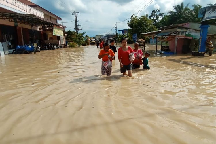 Sejumlah warga berusaha menerobos banjir yang melanda Kota Tebing Tinggi, Sumatera Utara.