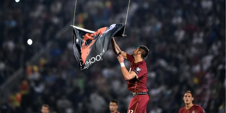 Pemain belakang Serbia, Stefan Mitrovic, menangkan dan menurunkan bendera dengan simbol Albania, yang sebelumnya diterbangkan menggunakan drone saat laga kualifikasi Grup I Piala Eropa 2016 antara Serbia dan Albania di Belgrade.