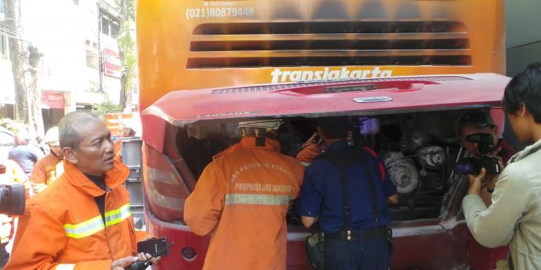 Beberapa petugas pemadam kebakaran mengecek bagian mesin bus transjakarta yang terbakar di Halte Stasiun Jatinegara 2. Dari mesin belakang bus ini diduga awal terjadinya kebakaran. Sabtu (18/7/2015).