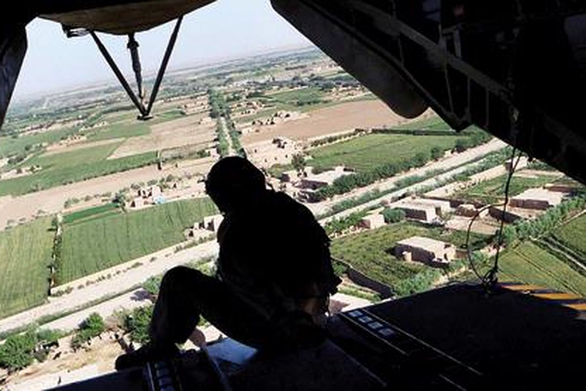 Seorang anggota pasukan helikopter CH 53 marinir AS duduk di pintu belakang heli saat mereka terbang melewati distrik Marjah, Provinsi Helmand, Pakistan, Selasa (3/5). Osama bin Laden tewas tertembak setelah disergap pasukan khusus dengan helikopter di kediaman mewahnya di Abbottabat, Pakistan, Senin.