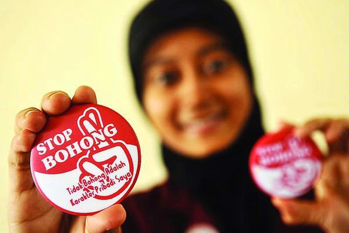 Yuni , mahasiswa Universitas Muhammadiyah Surabaya, menunjukkan pin ajakan untuk tidak berbohong di kampus itu, Rabu (19/1). Pin yang dibagikan kepada masyarakat dan warga kampus tersebut merupakan dukungan atas gerakan perlawanan terhadap kebohongan yang digulirkan sejumlah tokoh agama.