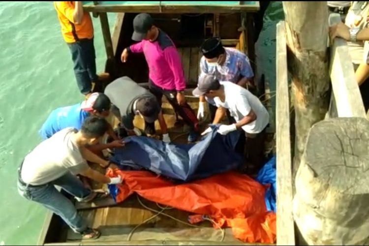 Sejumlah warga bersama petugas kelurahan mengevakuasi mayat tanpa kepala yang ditemukan mengapung di perairan Desa Mapur pagi tadi.