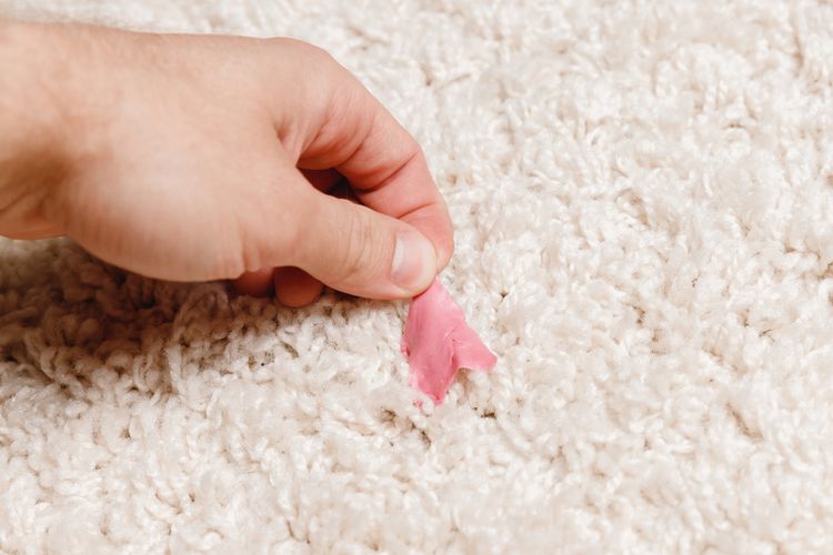 Ilustrasi permen karet menempel di karpet. 