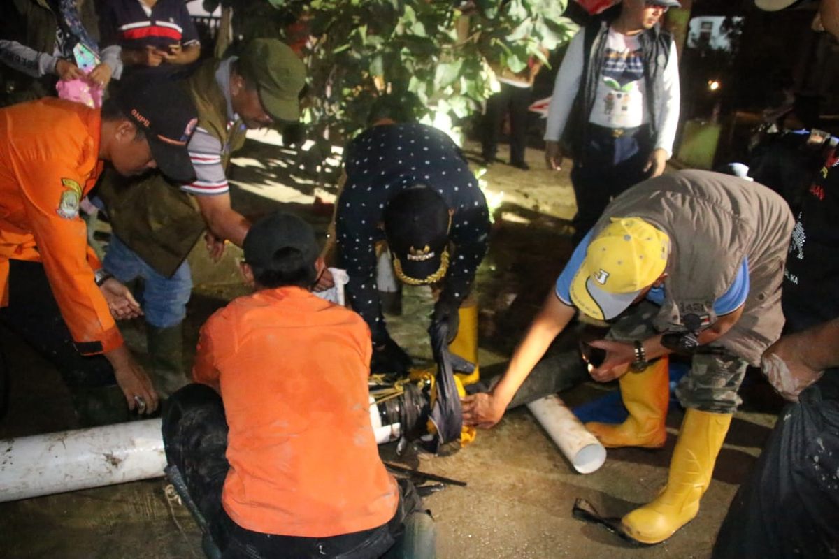 Wali Kota Bekasi, Rahmat Effendi (tengah) berjibaku mengakali pipa pengalir lumpur banjir yang bocor di Perumahan Pondok Gede Permai, Jatiasih, Kota Bekasi, Senin (13/1/2020) malam.