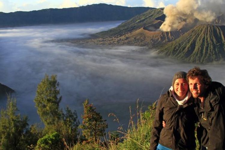 Sepasang turis asing berfoto dengan latar belakang Gunung Bromo dan Gunung Batok di Bukit Kingkong.