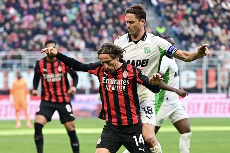 Luka Modric dibayangi Nemanja Matic dalam pertandingan sepak bola Serie A Liga Italia antara AC Milan vs Sassuolo di Stadion San Siro di Milan, Italia pada 14 Desember 2025. (Foto oleh Piero CRUCIATTI / AFP)
