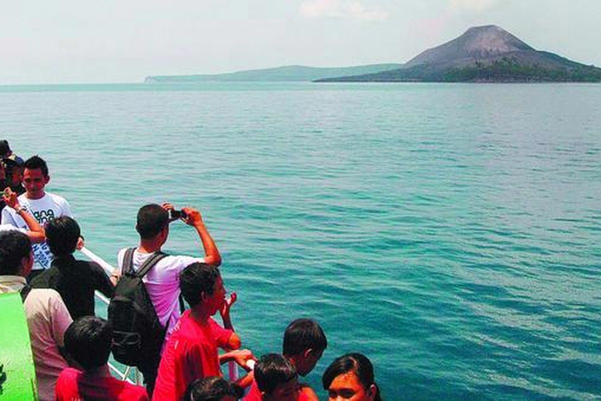 Wisatawan tengah melihat dan mengabadikan pemandangan Kepulauan Krakatau dari geladak Kapal Motor Penumpang Jatra III, di perairan Selat Sunda, Sabtu (15/11).  