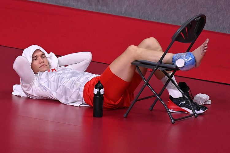 Atlet handball asal Denmark, Lasse Andersson, berbaring di pinggir lapangan dengan kaki terkompres setelah mengalami cedera engkel pada babak preliminary Grup B Olimpiade Tokyo 2020 melawan Bahrain di Yoyogi National Stadium. 28 Juli 2021.