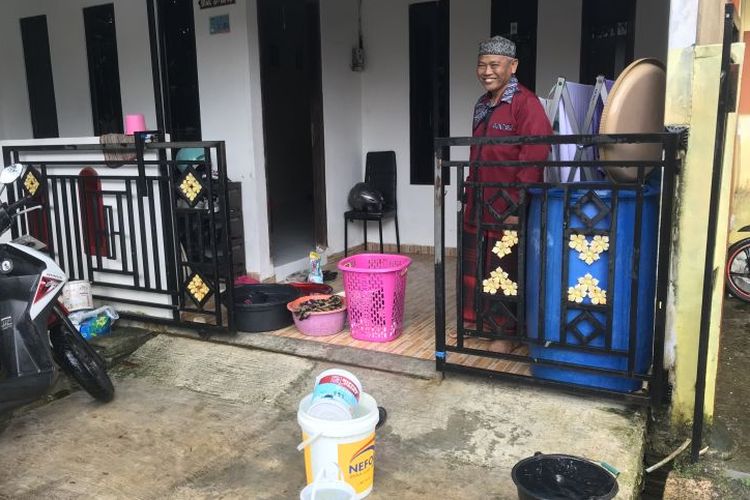Warga di Perumahan Bukit Raya, Batam,  Provinsi Kepri, Muchtar sedang mencuci baju di halaman rumahnya menggunakan air hujan karena suplai air bersih tidak mengalir selama empat hari di perumahan itu, Senin (23/1/2023).