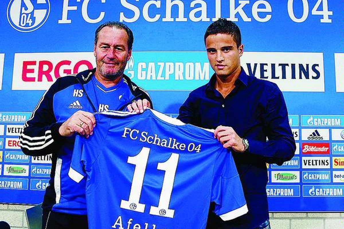 Pesepak bola Belanda, Ibrahim Afellay (kanan), dan Pelatih Kepala Schalke 04 Huub Stevens memamerkan kostum baru untuk Afellay seusai jumpa pers tim Bundesliga itu, Jumat (31/8), di Gelsenkirchen, Jerman. Afellay dipinjam untuk satu musim dari klub Spanyol, Barcelona.