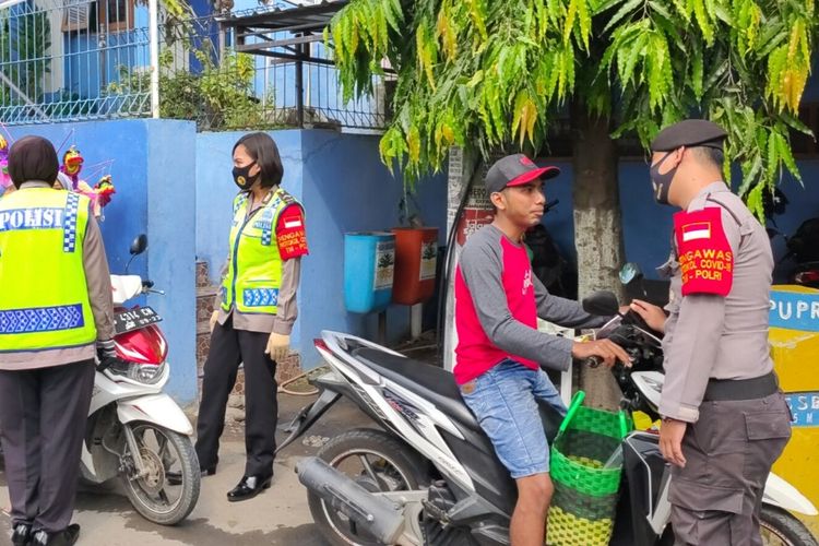 Petugas gabungan penegak disiplin new normal menghentikan warga tak memakai masker yang hendak masuk ke Pasar Sumurpanggang, Kota Tegal, Jawa Tengah, Rabu (10/6/2020)