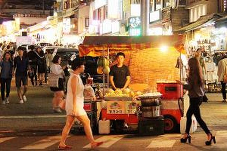 Orang berlalu lalang di kawasan Hondae, salah satu lokasi nongkrong terkenal di Seoul, Korea Selatan, Kamis (4/9/2014) malam.