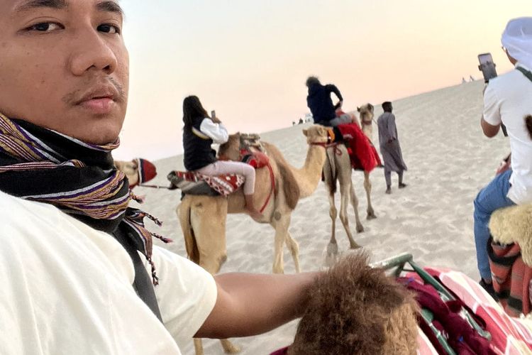 Jurnalis Kompas.com, Ferril Dennys Sitorus, yang meliput Piala Dunia 2022, menikmati keindahan padang pasir di Messaid, Qatar sekaligus naik unta pada Kamis (15/12/2022).