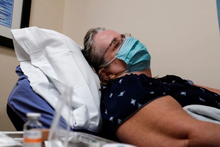 Seorang pasien bernama Cathy Hardin tampak berbaring di ranjang di rumah sakit Sarasota Memorial Urgent Care Center di Sarasota, Florida, pada 23 September 2021. Cathy positif terjangkit virus corona di tengah merebaknya varian Delta di AS.