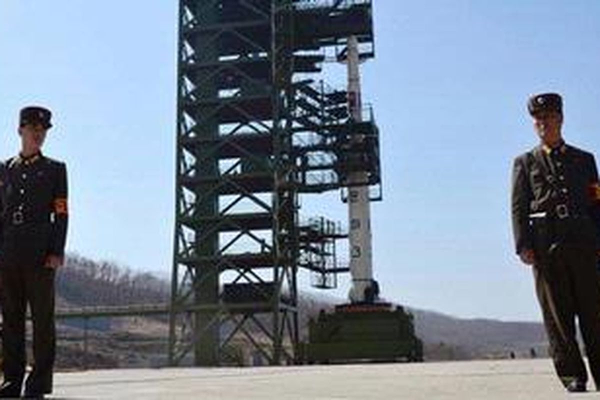 Foto ini diambil pada 8 April 2012 menunjukkan dua prajurit AD Korea Utara menjaga roket Unha-3 di pusat angkasa luar Tangachai-ri. Korea Utara akhirnya meluncurkan roket jarak jauhnya pada Rabu (12/12/2012), meski mendapat kecaman keras dari dunia internasiona. 