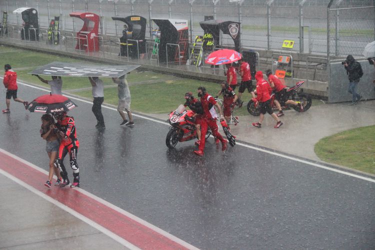 Suasana saat para pebalap dan kru tim tergesa-gesa kembali ke paddock di tengah hujan deras yang mengguyur kawasan Sirkuit Mandalika jelang Race 1 kelas World Superbike, Sabtu (20/11/2021).