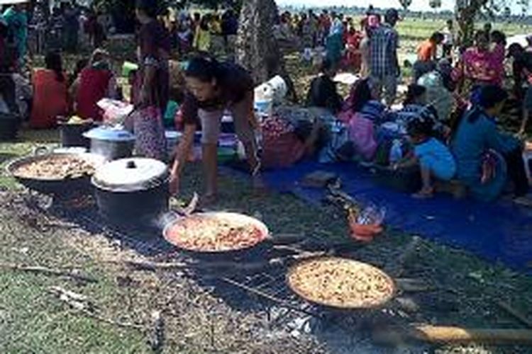 Sejumlah ibu rumah tangga (IRT) di Kabupaten Bone, Sulawesi Selatan tengah mempersiapkan makan untuk disantap bersama dalam ritual pesta penen raya di sumur kaki raksasa. Minggu, (15/09/2013).