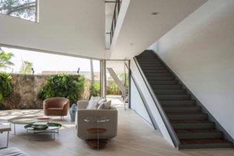 Tangga menuju upper level sengaja didesain tanpa pegangan dan landai. Selain mudah dilalui, tangga yang menempel pada dinding ini tidak menutupi visual dan tetap mempertahankan efek luasnya rumah ini.