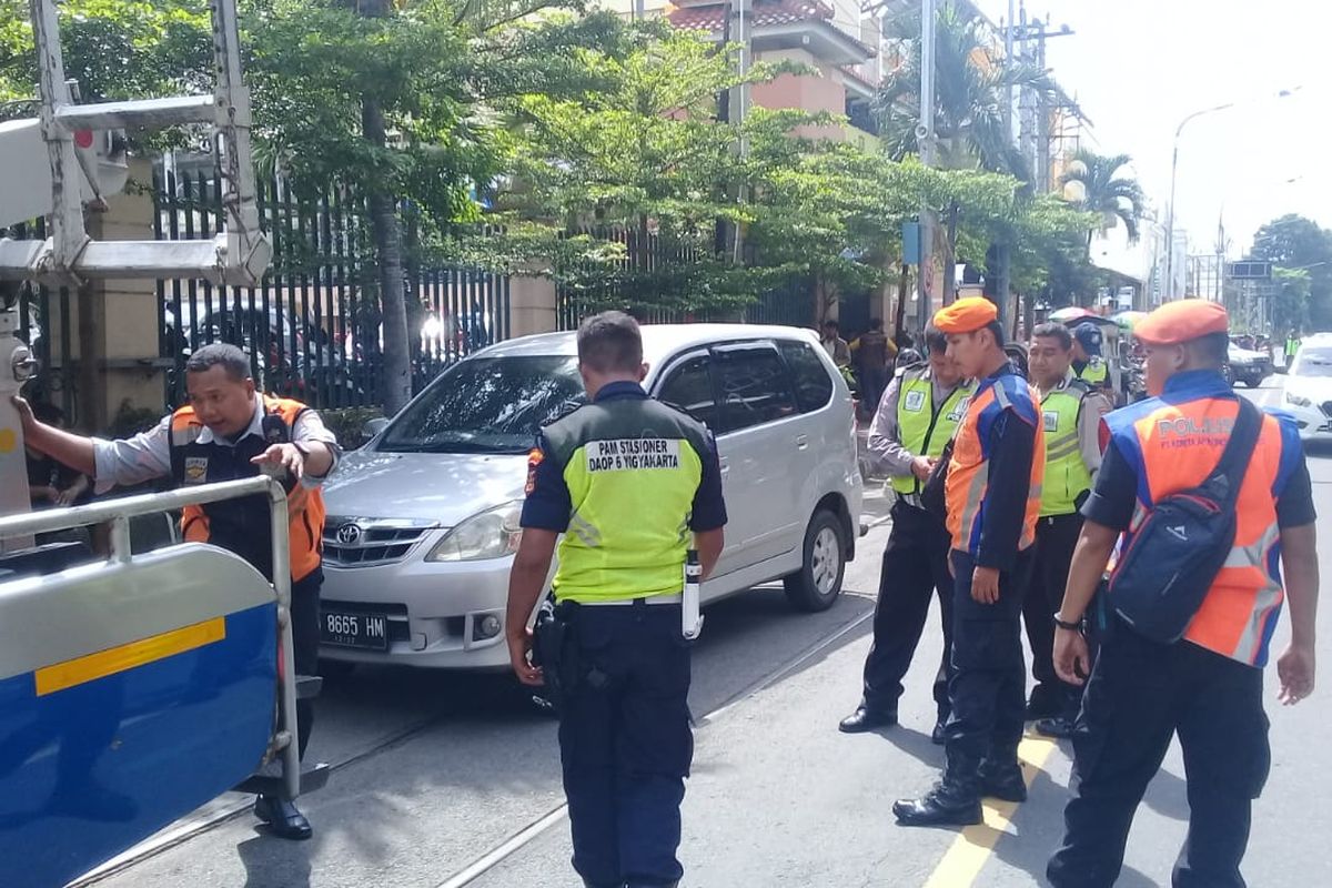 Sejumlah petugas menderek mobil Toyota Avanza yang nekat parkir di atas perlintasan kereta api di jalan Mayor Sunaryo, Solo, Jawa Tengah.