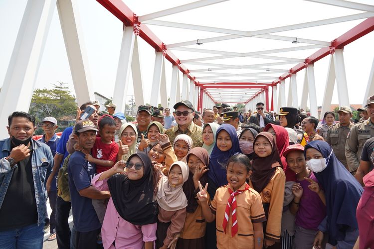 Warga di sekitar Jembatan Jongbiru antusias berfoto bersama Bupati Kediri Hanindhito Himawan Pramana atau Mas Dhito usai peresmian dan pembukaan kembali Jembatan Jongbiru di kecamatan Gampengrejo, Kabupaten Kediri, Jawa Timur, Indonesia, Kamis (25/7/2024).