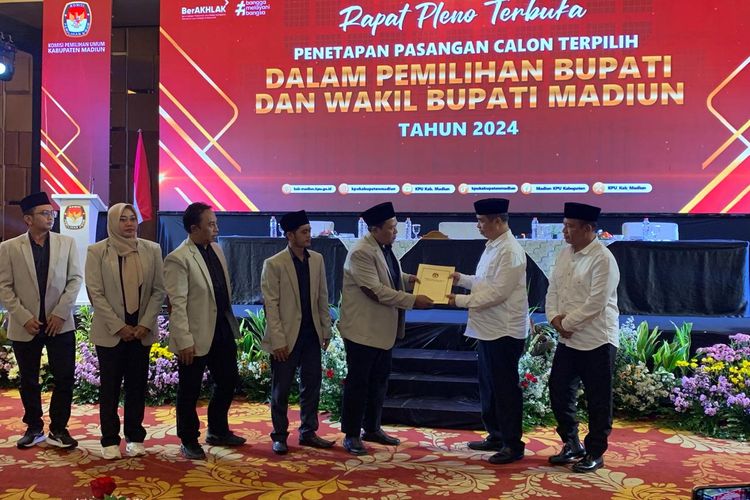 SERAHKAN--Ketua KPU Kabupaten Madiun, Nur Anwar menyerahkan surat keputusan penetapan bupati dan wakil bupati Madiun terpilih kepada Hari Wuryanto-Purnomo Hadi yang menang dalam pilkada serentak 2024 di Bima Ballroom Aston Hotel Madiun, Kamis (9/1/2025). 