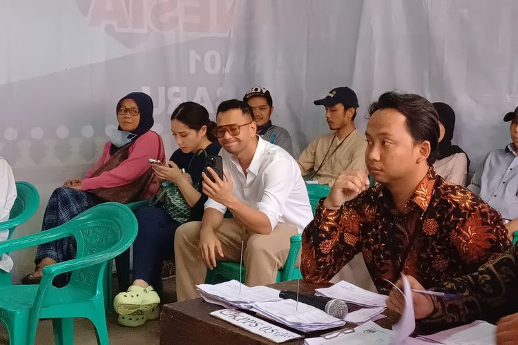 Presenter Raffi Ahmad sempat ditegur petugas KPPS berkemeja batik coklat karena merekam video dirinya dengan ponsel di dalam TPS 001 Pangkalan Jati Baru, Depok, Rabu (14/2/2024).