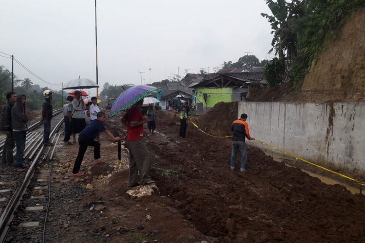  Petugas kepolisian dari Polsek Cicurug memasang garis polisi di tempat kejadian perkara tanah longsor di Cicurug, Sukabumi, Jawa Barat, Kamis (10/1/2019).