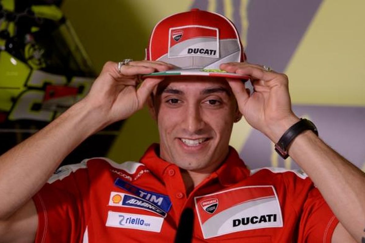 Pebalpa Ducati asal Italia, Andrea Iannone, membetulkan topi dan tersenyum saat konferensi pers jelang GP Catalunya di Sirkuit de Barcelona-Catalunya, Kamis (2/6/2016).