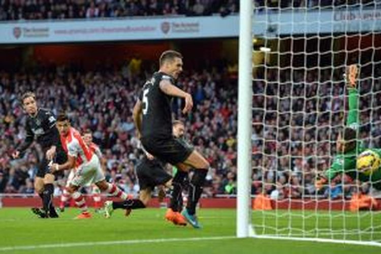 Penyerang Arsenal, Alexis Sanchez, mencetak gol ke gawang Burnley, pada pertandingan lanjutan Premier League, Sabtu (1/11/2014). 