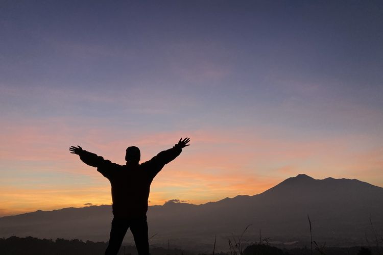 Seorang wisatawan tengah menikmati pemandangan Gunung Gede Pangrango detik-detik menjelang momen golden sunrise yang dilihat dari Desa Pasirjaya, Kecamatan Cigombong, Kabupaten Bogor pada Kamis (27/5/2021).