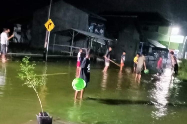Warga mencari ikan yang lepas dari tambak setelah diterjang banjir rob di Kelurahan Muarareja, Kecamatan Tegal Barat, Kota Tegal, Jawa Tengah, Senin (23/5/2022) malam. (Istimewa). 
