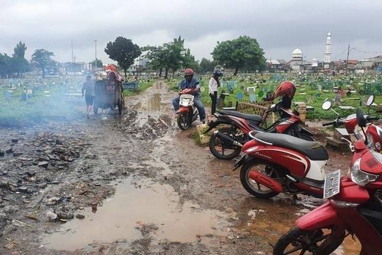 Akses jalan di TPU Prumpung yang hanya beralaskan tanah merah rusak parah dan becek saat musim hujan tiba, Minggu (2/2/2020)