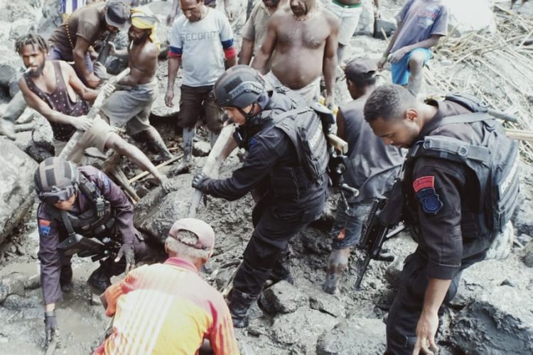 Tanpak anggota Brimob bersama masyarakat melakukan pencarian korban tertimbun longsor di Tolikara, Papua, Selasa (15/1/2018).