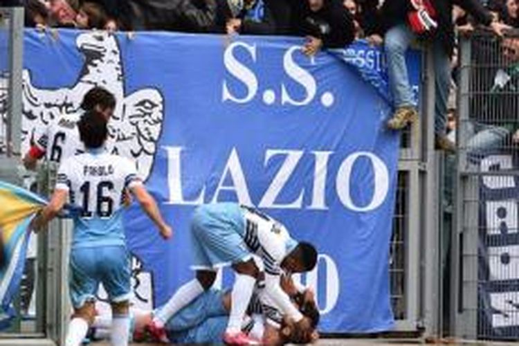 Gelandang Lazio, Antonio Candreva (bawah), mengalami cedera saat melakukan selebrasi mencetak gol ke gawang Palermo, di Olimpico, Roma, Minggu (22/2/2015).