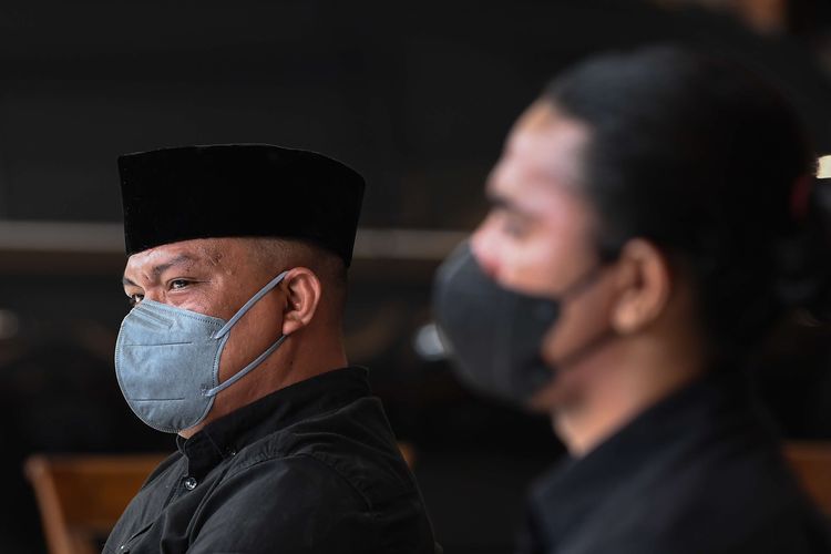 Terdakwa unlawful killing anggota Laskar FPI Ipda M Yusmin Ohorella (kiri) dan Briptu Fikri Ramadhan mendengarkan pembacaan putusan dalam sidang yang digelar secara virtual di Jakarta, Jumat (18/3/2022). Majelis Hakim PN Jakarta Selatan memvonis bebas kedua terdakwa meski dakwaan primer jaksa terbukti, perbuatan terdakwa tidak dapat dikenai pidana karena masuk dalam kategori pembelaan terpaksa dan pembelaan terpaksa yang melampaui batas.