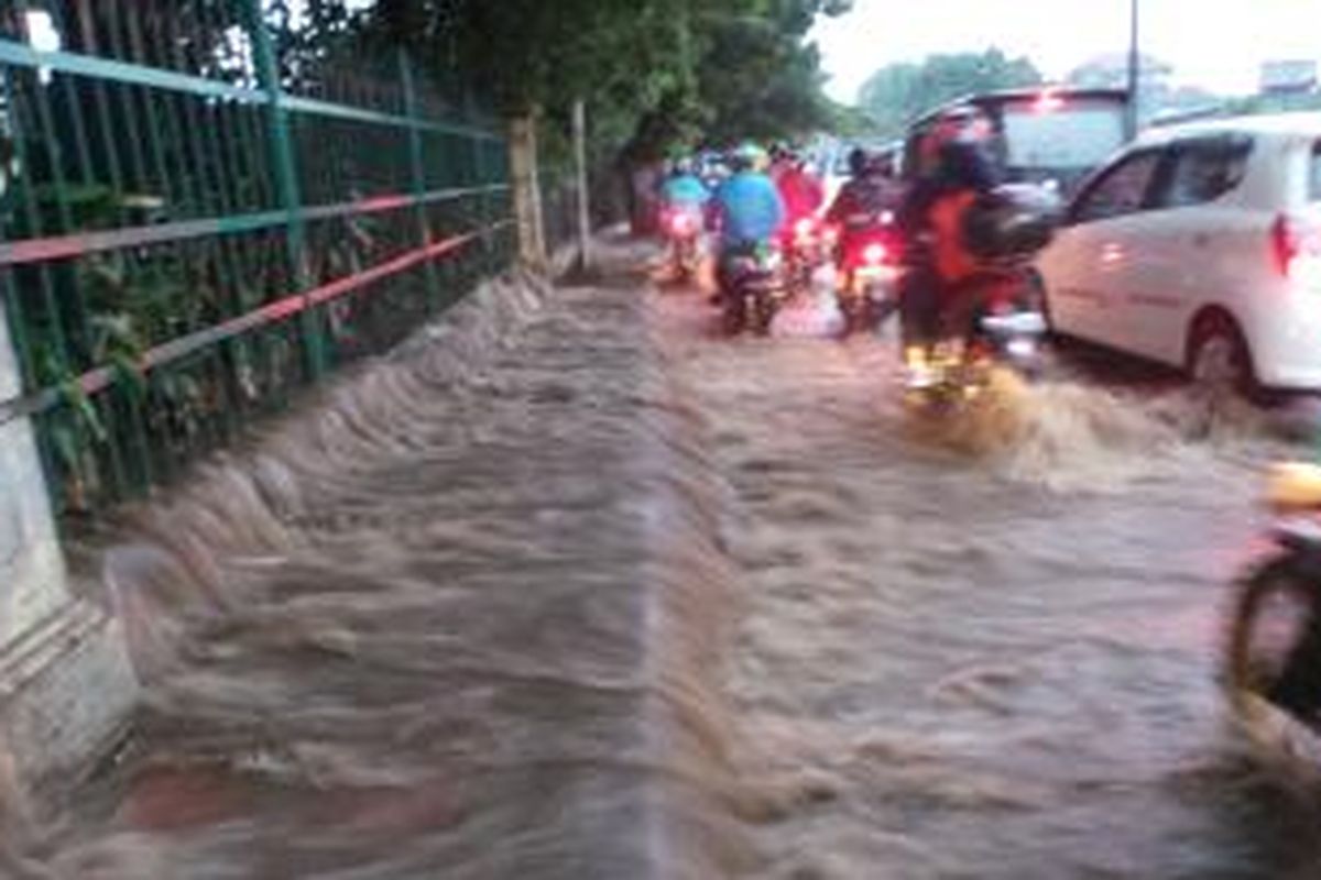 Luapan air Kali Baru membanjiri jalan di Pertigaan Hek, Kramatjati, Jakarta Timur, Senin (24/11/2014) sore.